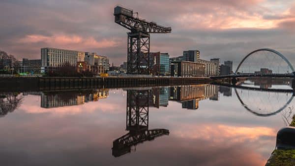 Stunning sunset view of Glasgow's River Clyde, featuring iconic structures and reflections.